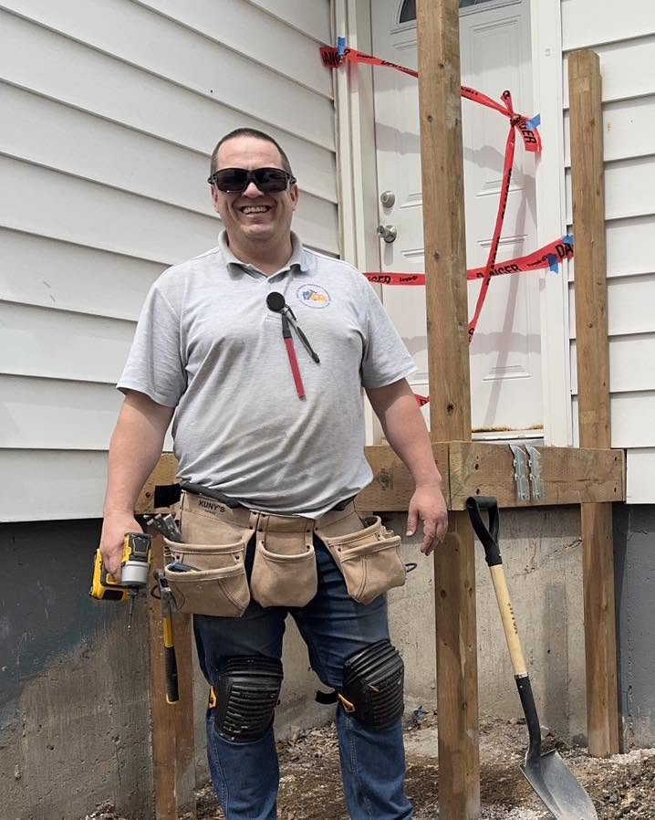 Fixit & Handy craftsman with tool belt and drill on an exterior deck build site.